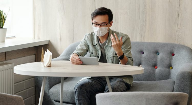 homem-usa-mascara-e-nao-quer-embaçar-os-óculos-sentado-usando-o-celular-em-cima-da-mesa