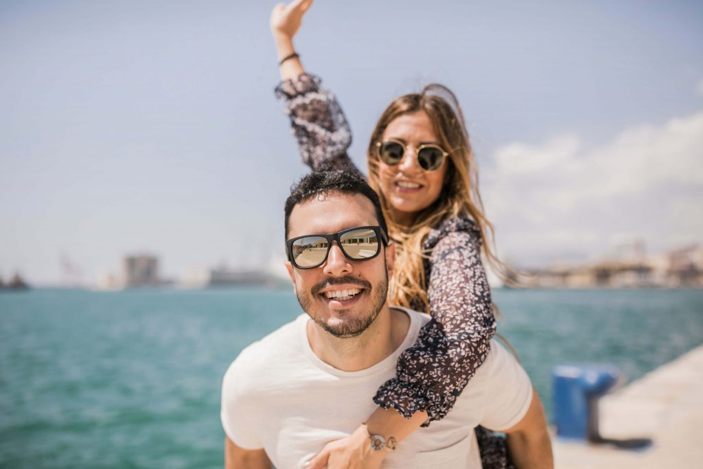 casal de homem e mulher usando óculos escuros para proteger os olhos no verão