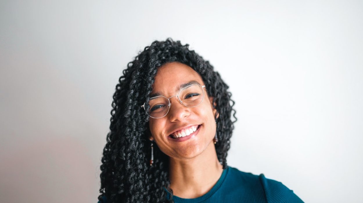 mulher negra, sorri, com seus olhos saudáveis, enquanto usa seus óculos e olha para a câmera ricardo magro
