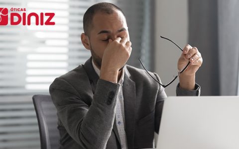 homem com uma mão nos olhos e outra mão segurando os óculos