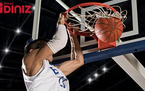 Jogador de basquete se pendura na cesta ao empurrar a bola NBA