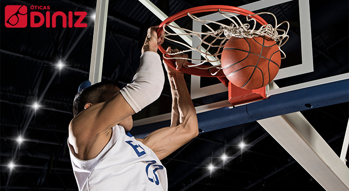 Jogador de basquete se pendura na cesta ao empurrar a bola NBA