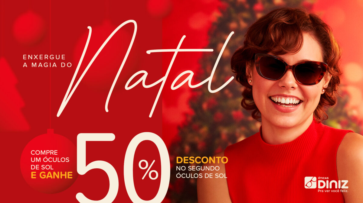 Na imagem, h&aacute; uma mulher branca sorrindo de cabelo ondulado, com &oacute;culos de sol e blusa vermelha em frente h&aacute; uma &aacute;rvore de natal iluminada e enfeitada. A montagem tem o texto: "Enxergue a magia do Natal! Compre um &oacute;culos de sol e grane 50% desconto no segundo &oacute;culos de sol".
